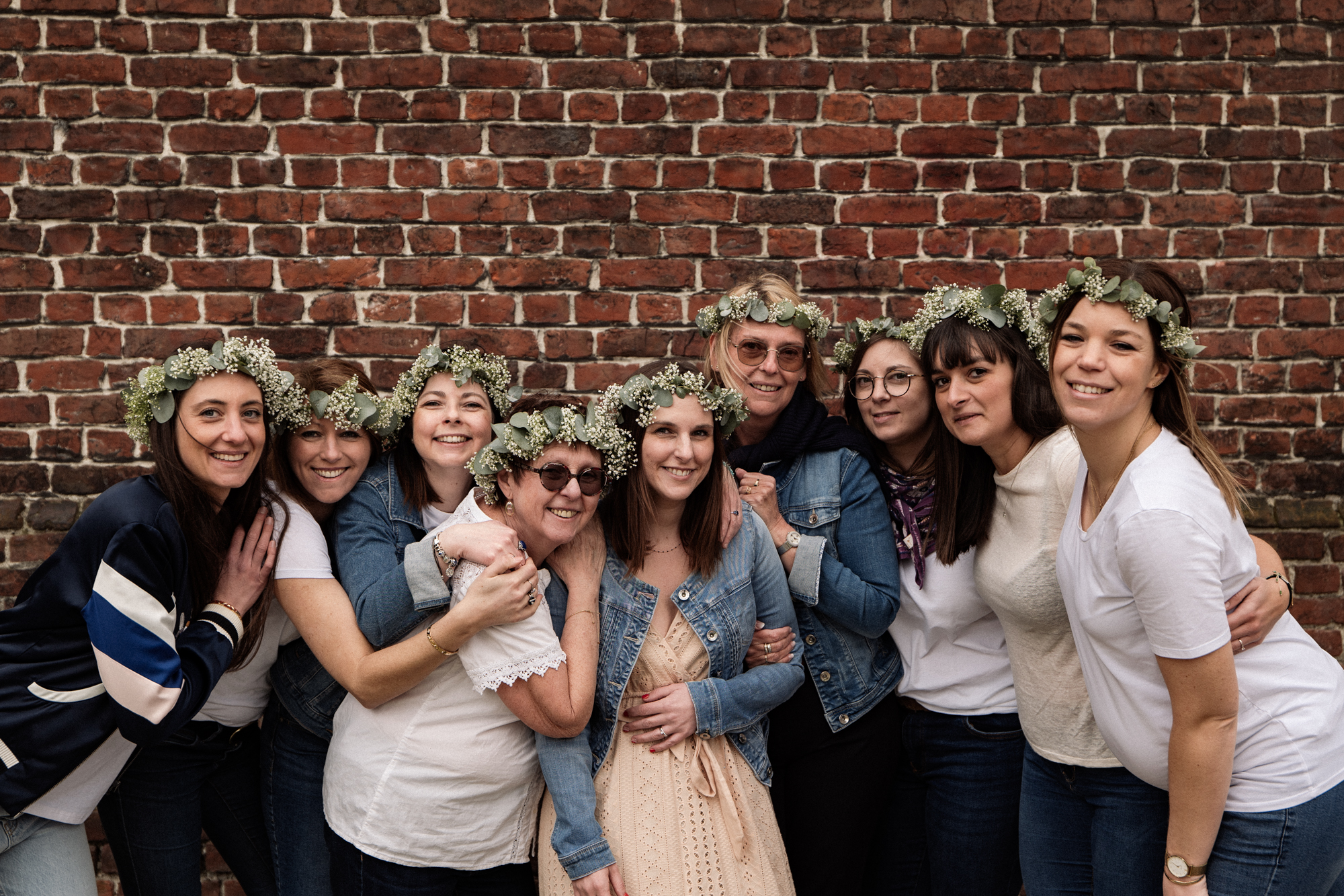 Photographie d'un groupe d'amies adossées contre un mur et portant une couronne de fleurs près de la Cathédrale de la Treille à Lille lors d'un EVJF