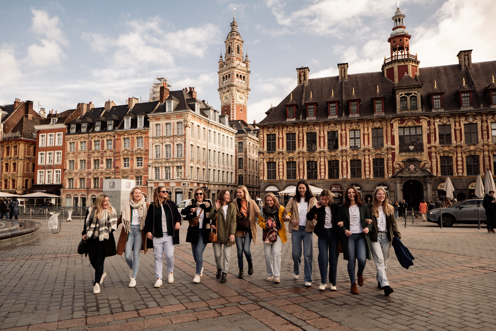 Photographie d'un groupe d'amies devant le Beffroi sur la Grande Place de Lille avançant vers la caméra lors d'un EVJF