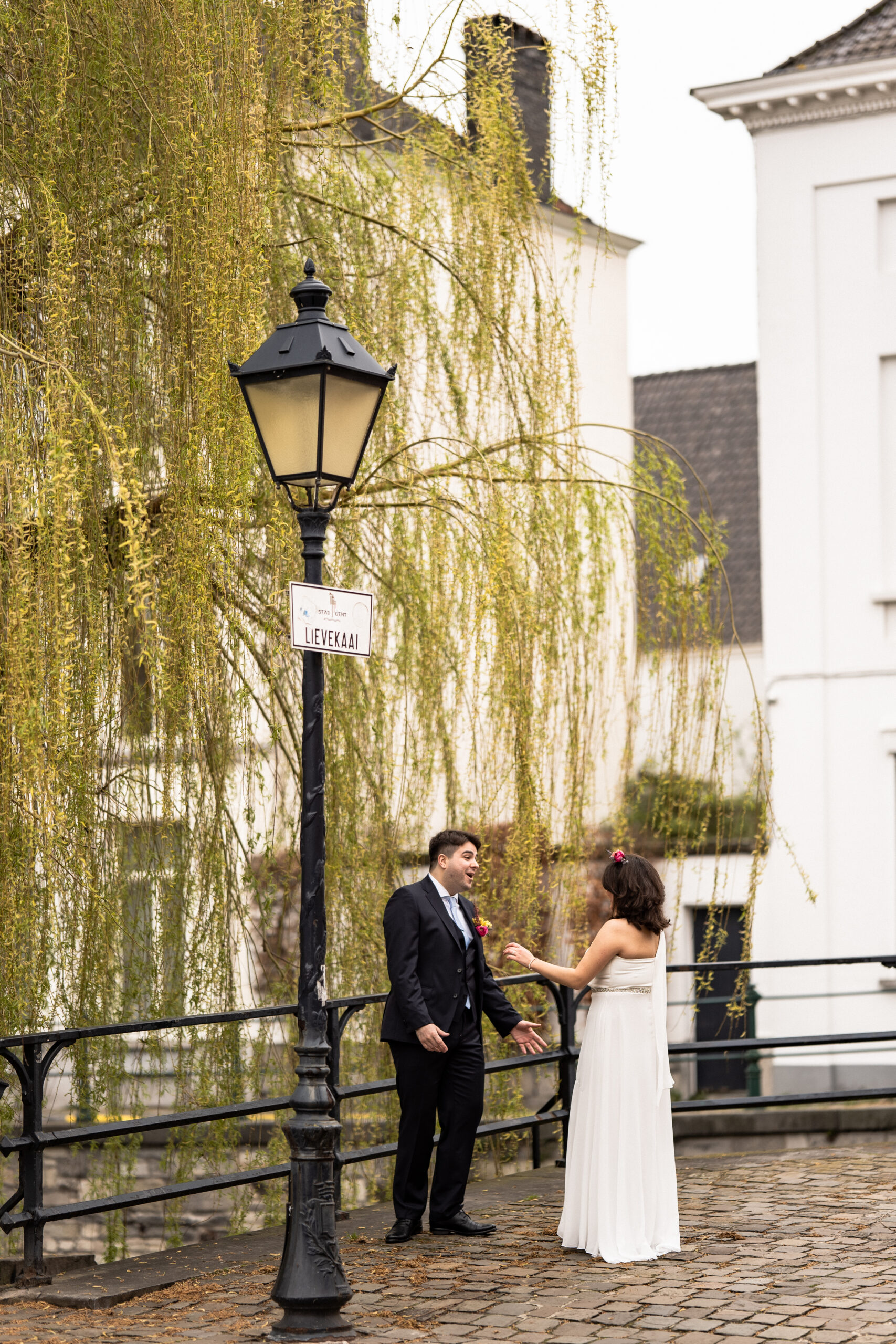 Photographie d'un couple de mariés lors de la découverte de leur tenue de mariage dans une ruelle de Gand en Belgique