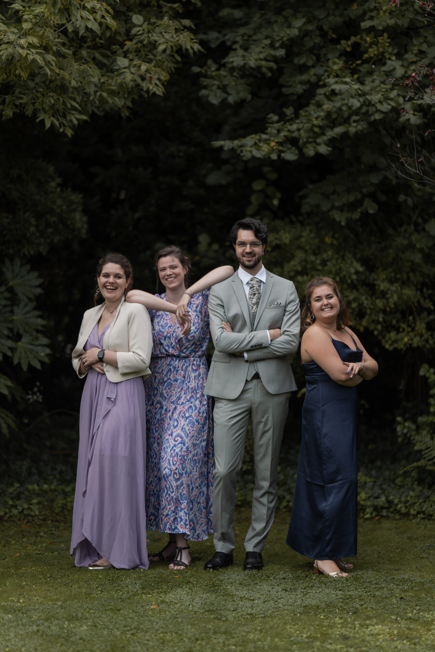 Photographie d'un marié entouré de 3 des ses amies dans un jardin posant lors d'une séance photo de groupe pendant son mariage