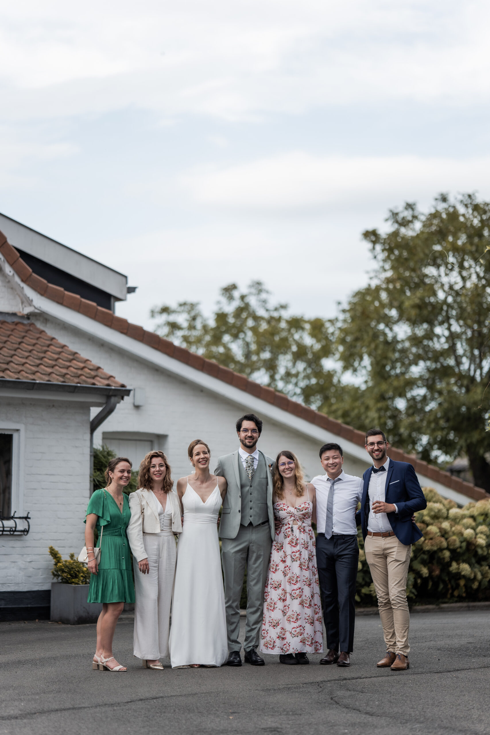 Photographie d'un couple de mariés avec certains de leurs invités lors d'une séance photo de groupe pendant leur mariage