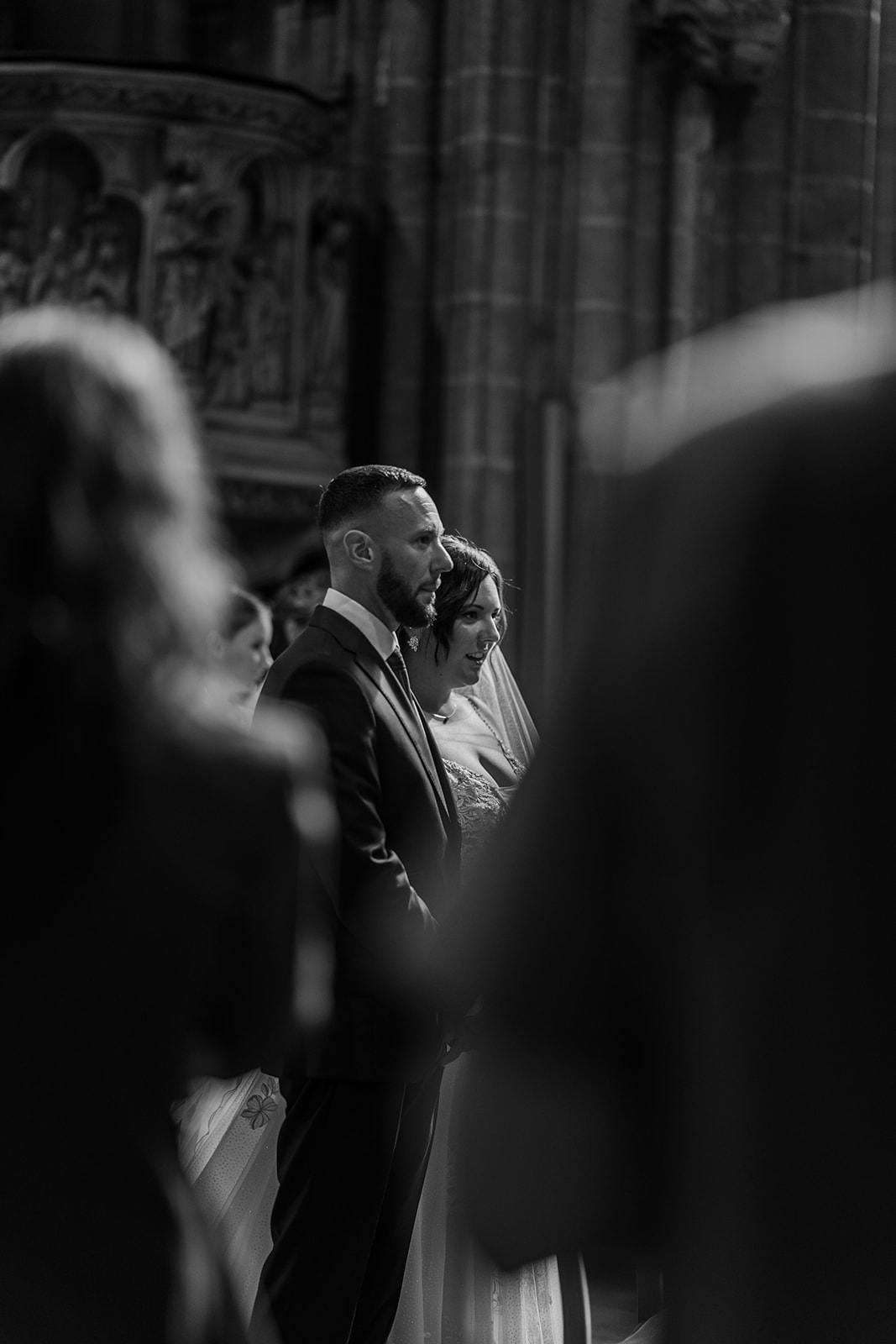 Photographie en noir et blanc d'un couple de marié lors de leur cérémonie religieuse dans l'église d'Ostende lors de leur mariage