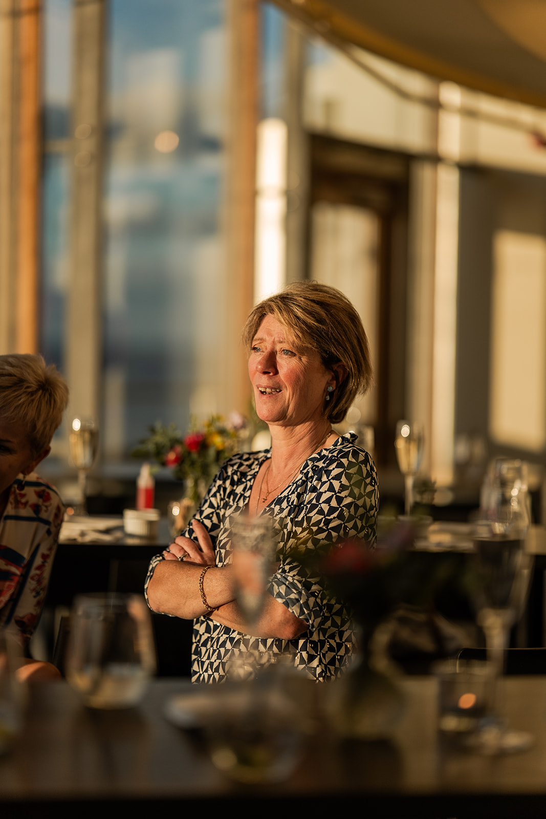 Photographie d'une invitée riant en regardant vers la fenêtre lors d'un vin d'honneur d'un mariage dans le Pier de Blankenberge