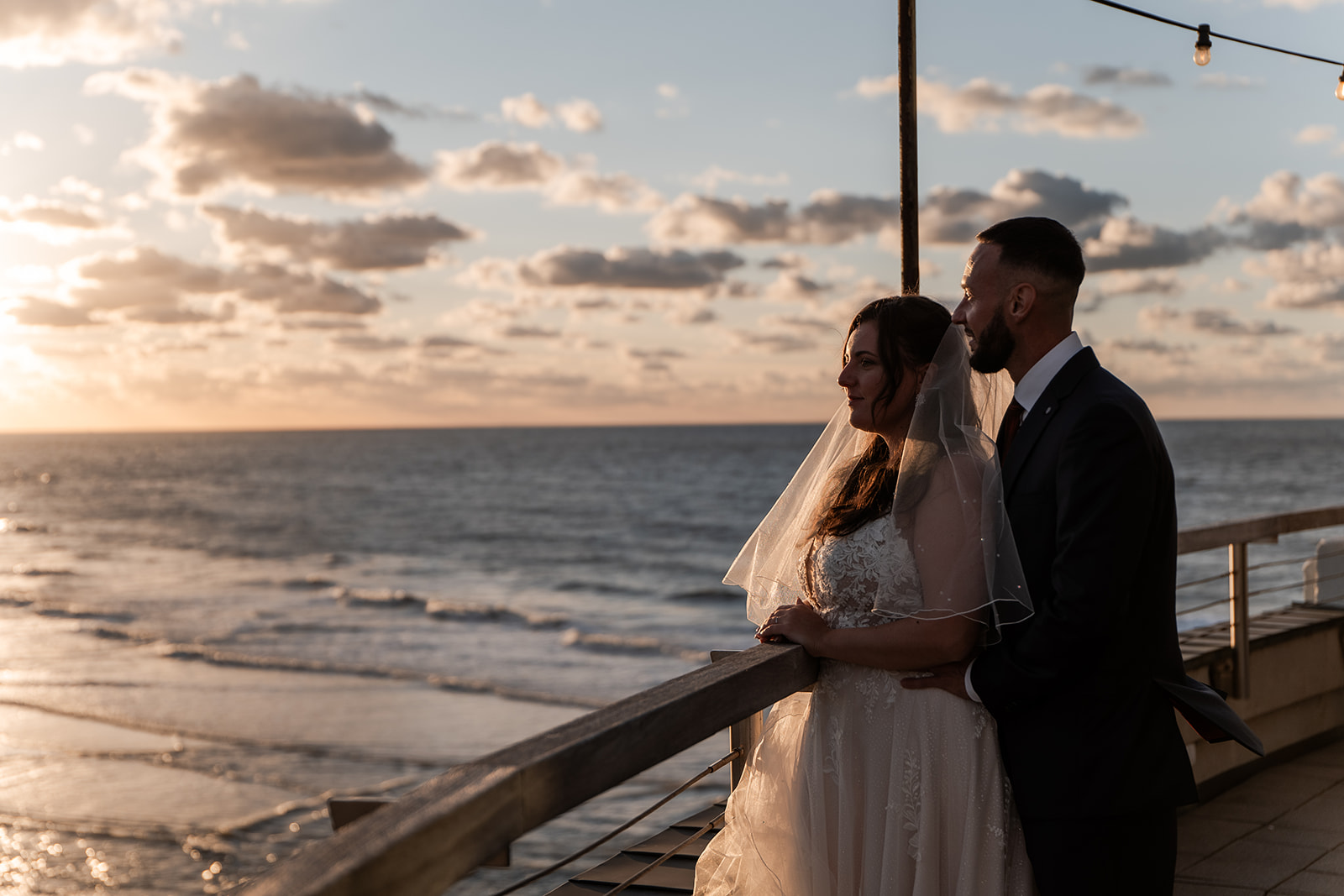 Photographie d'un couple de mariés sur la terrasse du Pier au dessus de la plage de Blankenberge lors de leur mariage