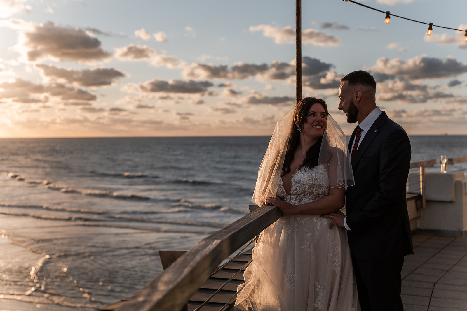 Photographie d'un couple de mariés sur la terrasse du Pier au dessus de la plage de Blankenberge lors de leur mariage